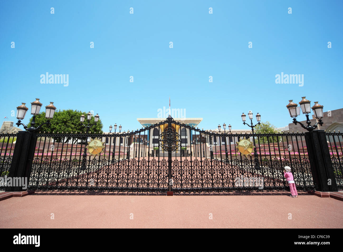 Entrance to the Sultan's Palace in Oman. little girl wearing panama hat looking at building. Stock Photo