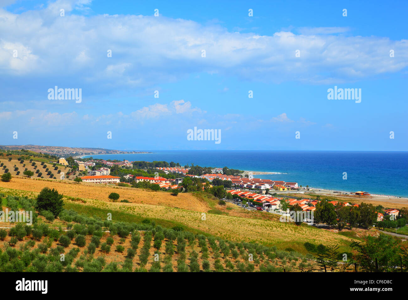 White houses on coast near hill with green trees and bushes Stock Photo