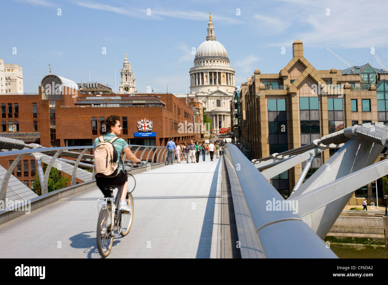A cyclist crossing the Millennium bridge heading towards St Paul's Cathedral on the North side of the River Thames. Stock Photo