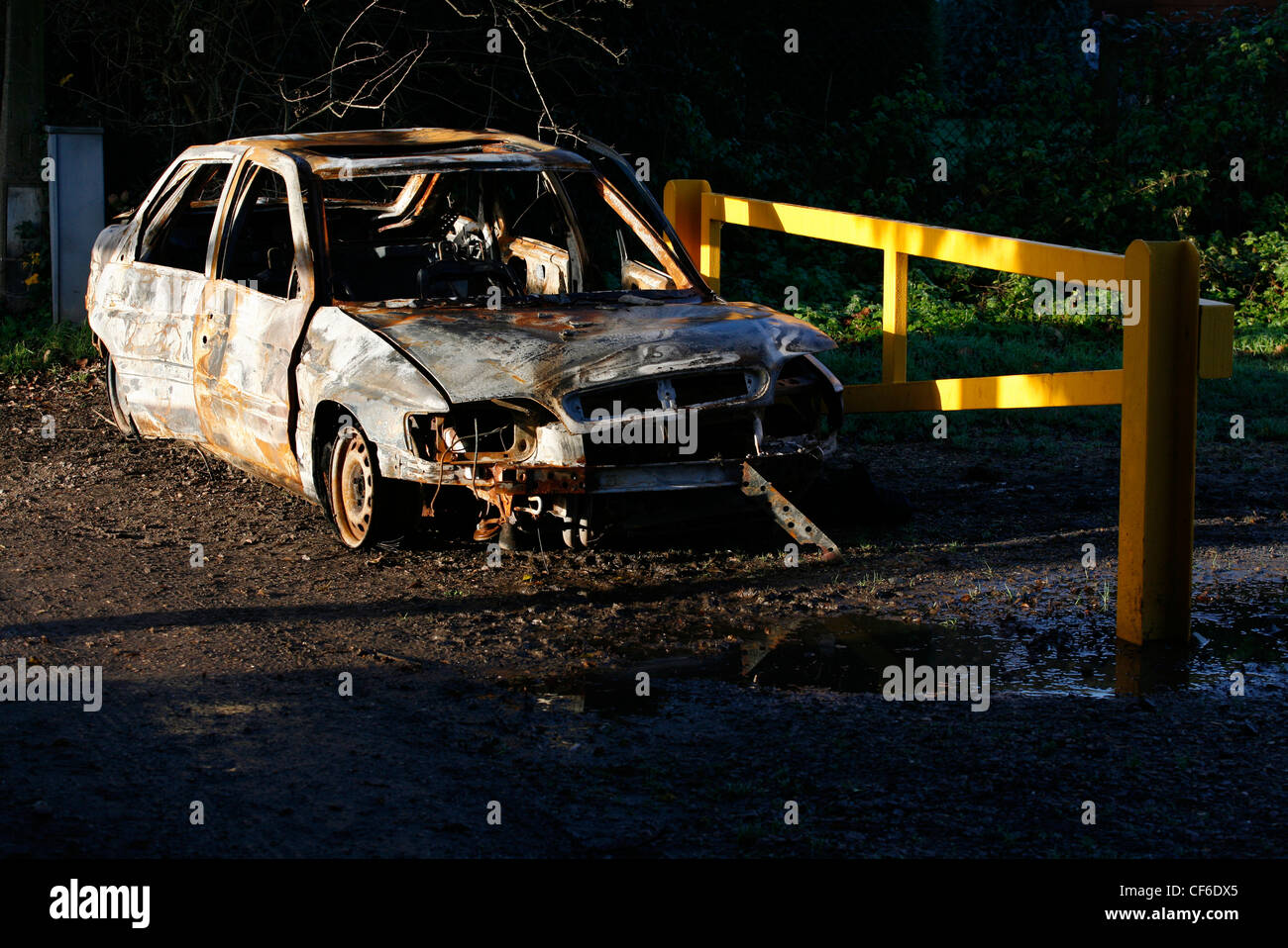 A burnt out car in sunlight. Every year in the UK around 200 cars a day go up in flames with 65% of these fires started delibera Stock Photo