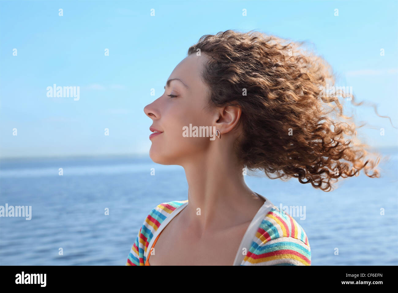 Profile of woman of which in  face blows marine wind Stock Photo