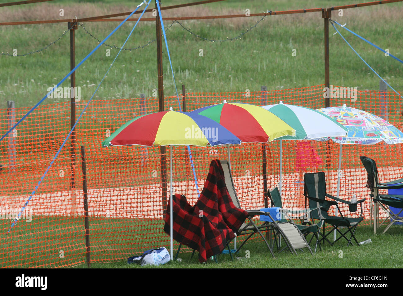 Colorful umbrellas in a row.  Show goers shelter themselves form the rain with a variety of umbrellas. Stock Photo