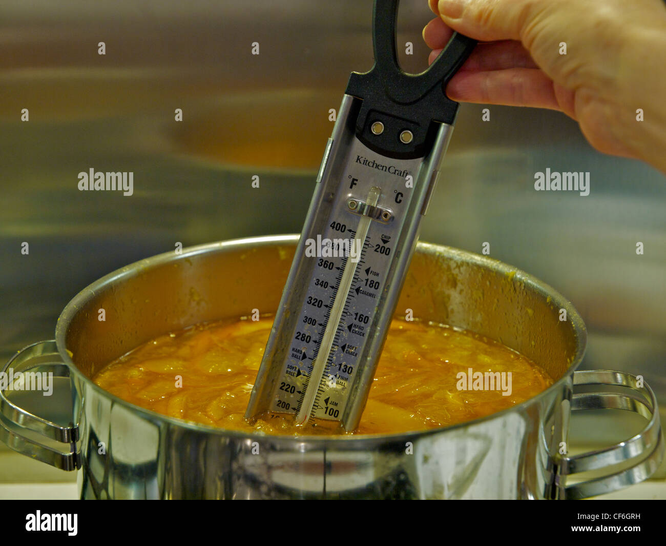 Checking the temperature of homemade marmalade with a food thermometer