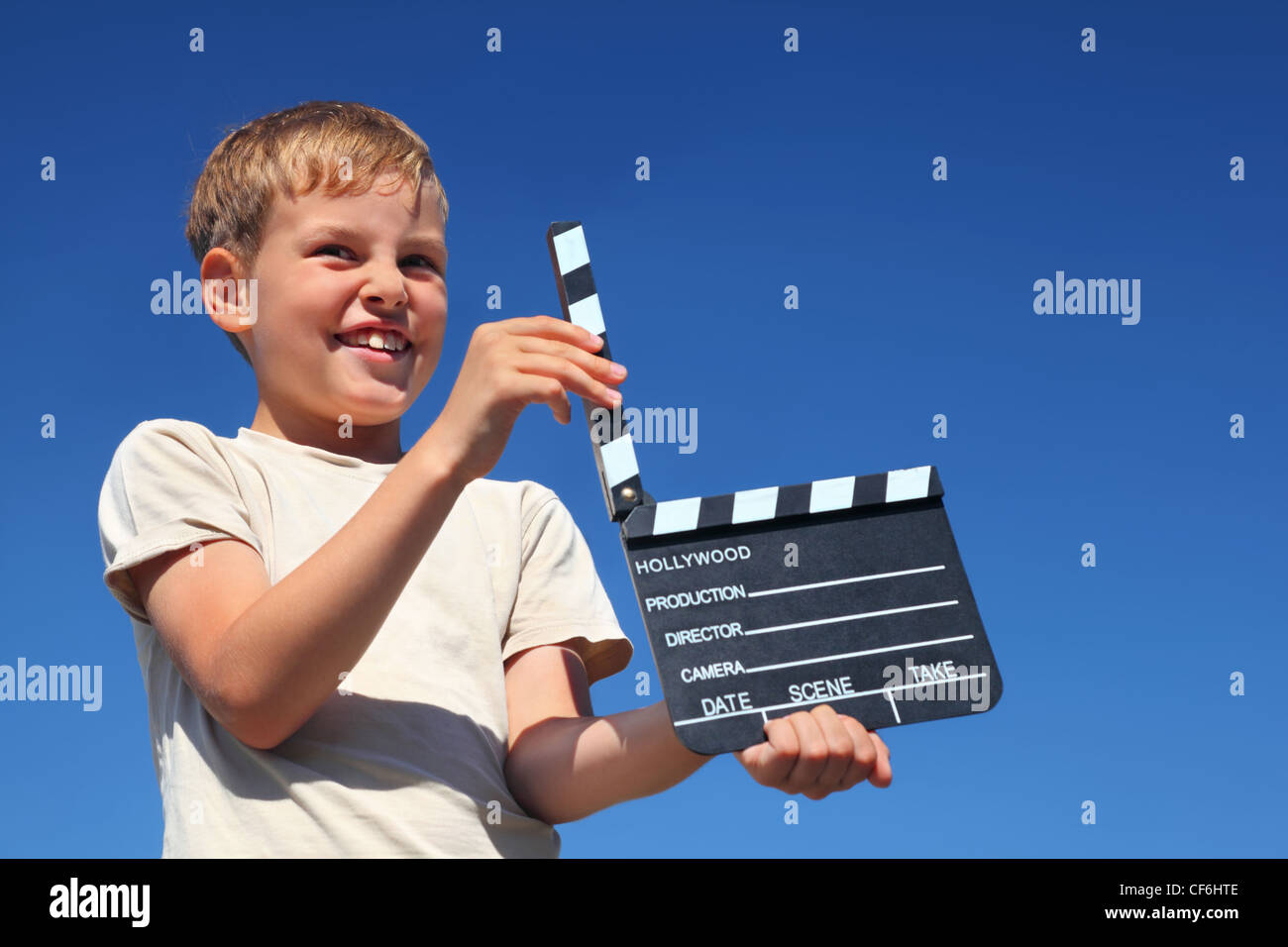 Boy gets on  hip  clapstick and smiles Stock Photo