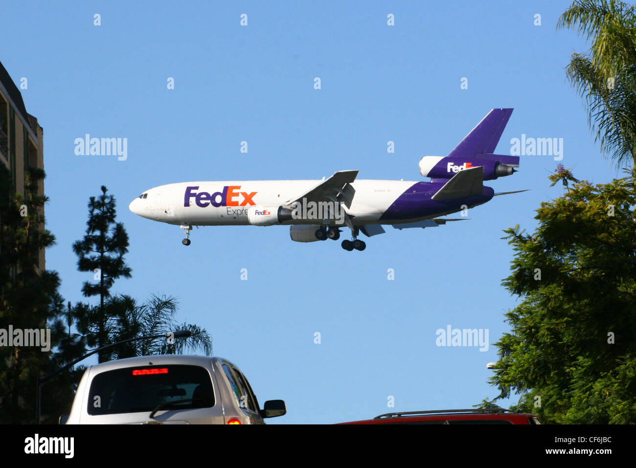 Fedex Airplane coming in for a landing over a large city. Stock Photo