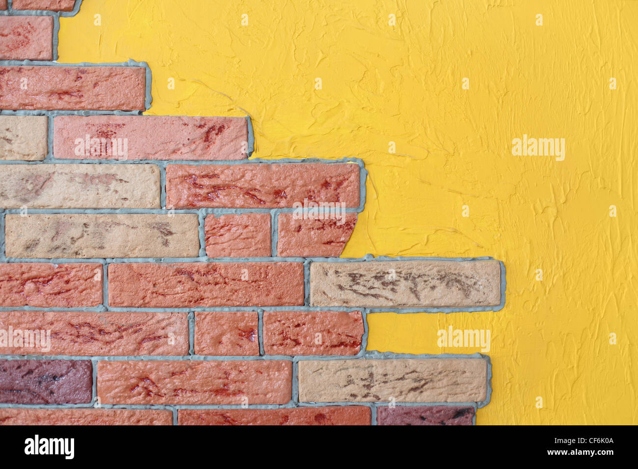 closeup of red brick wall and yellow plaster wall, bright interior Stock Photo