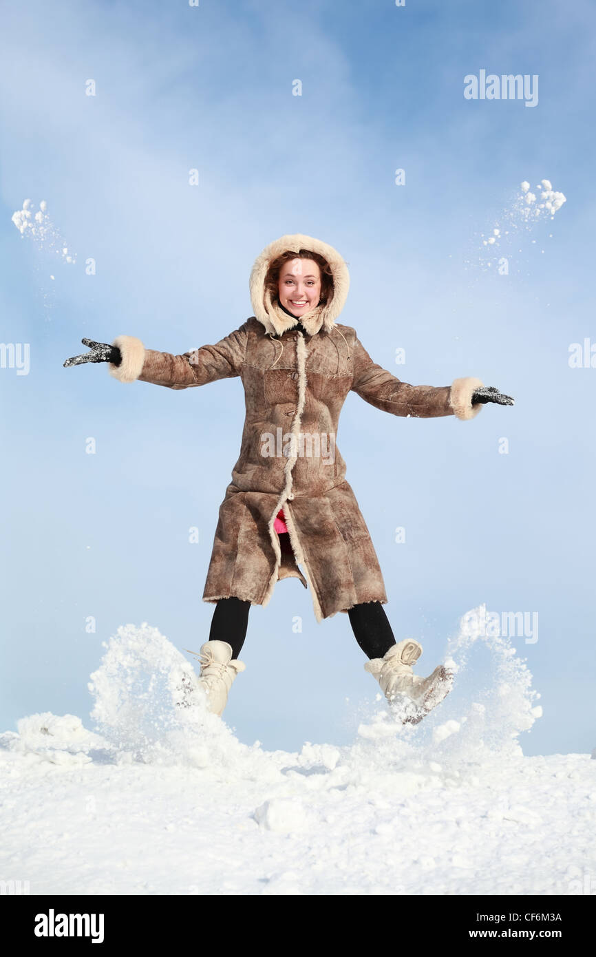 Girl jumps and throw snow hands and feet Stock Photo