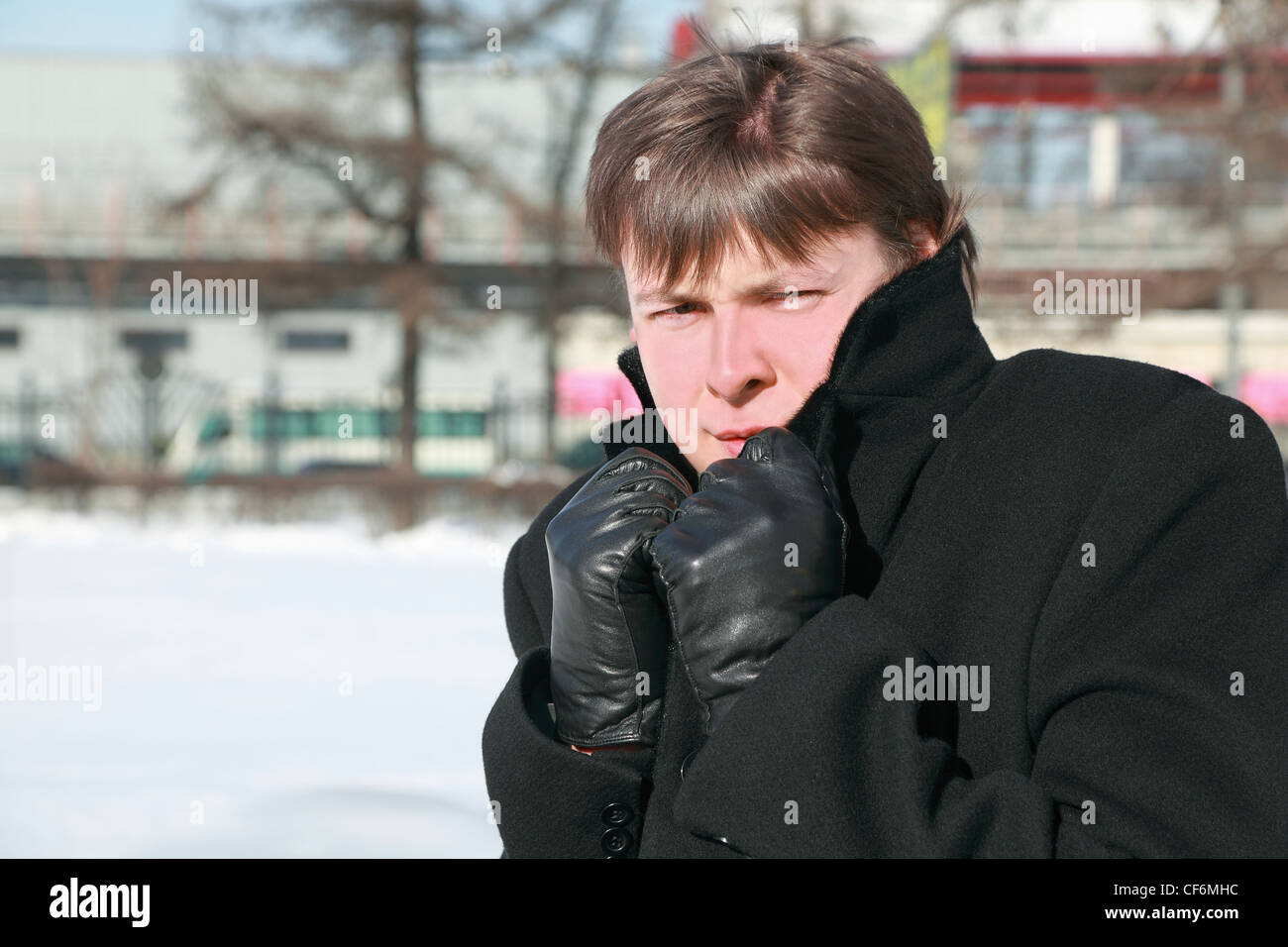 Young man froze in winter and hides head in collar Stock Photo