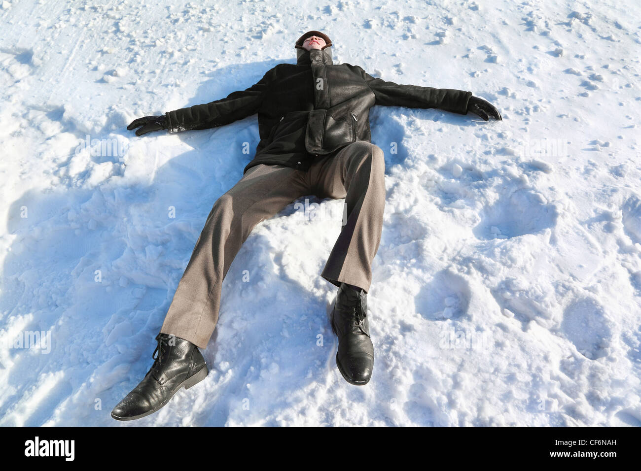 Man lies on back by  winter day and rests closing eyes Stock Photo