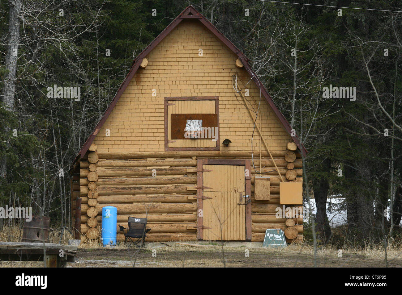 Old log  barn in a wooded area Stock Photo