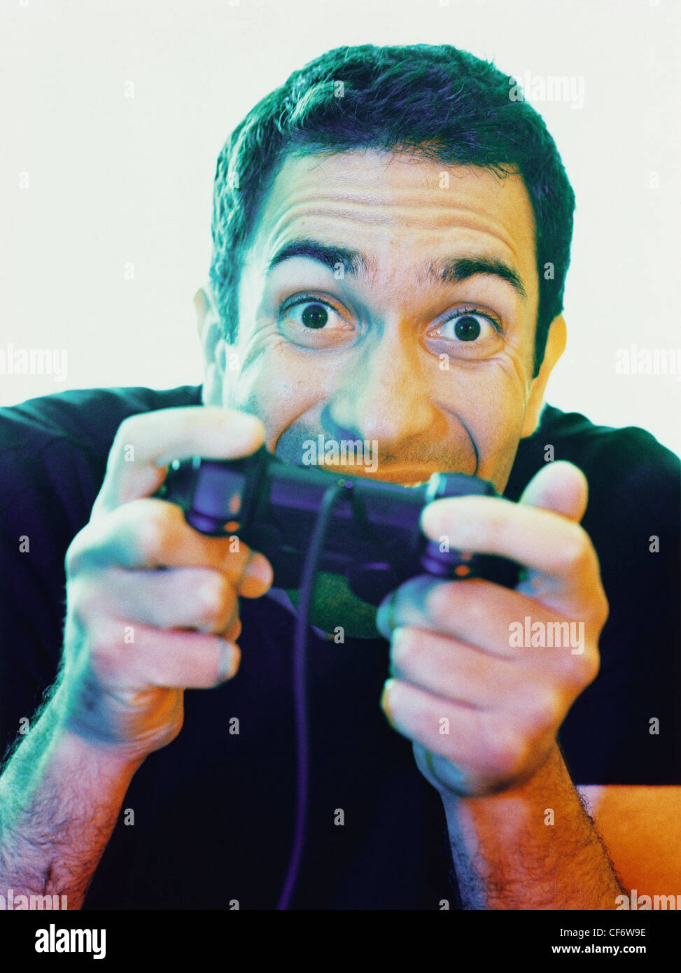 Male short brown hair playing playstation video game controls up to face eyes wide open posessed expression on face Stock Photo