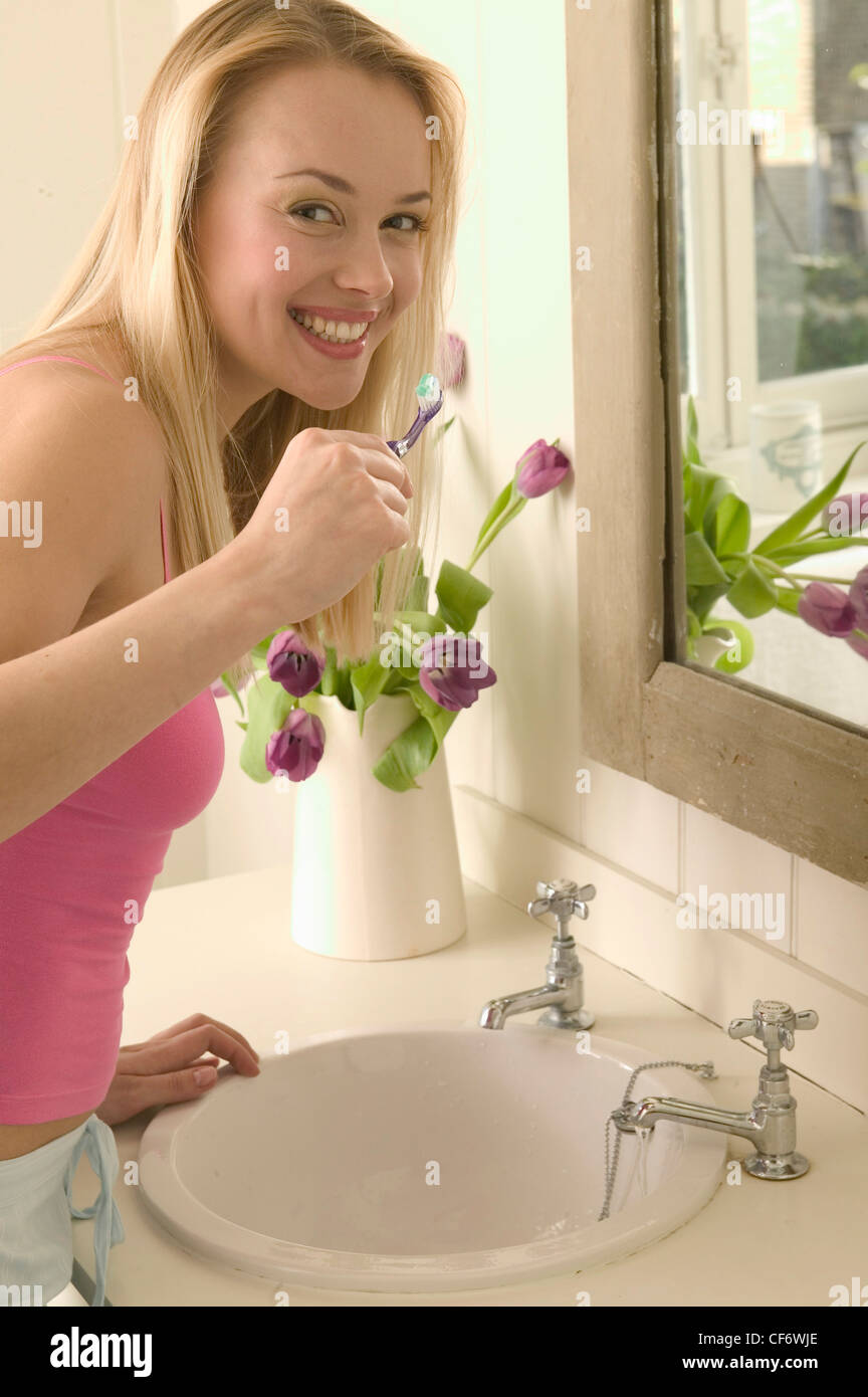 Female Long Blonde Hair Wearing Pink Vest Top And Light Blue