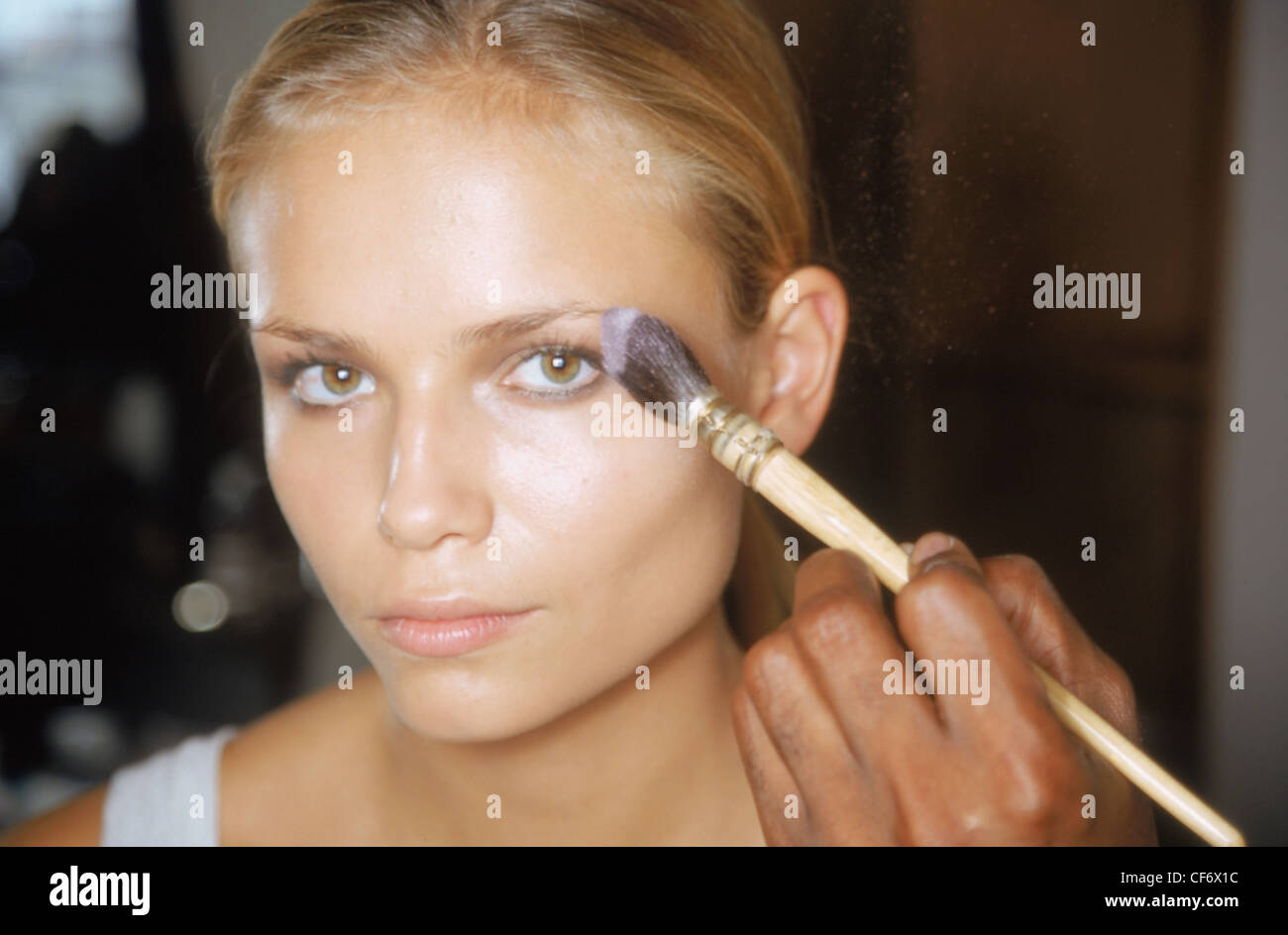 Backstage New York Spring Summer Calvin Klein Model blonde hair off face  having make up applied by professional make up artist Stock Photo - Alamy