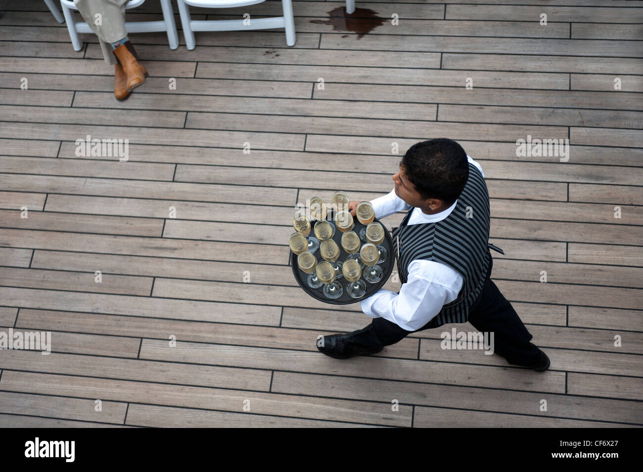 A waiter carrying glasses of champagne on a cruise ship during a