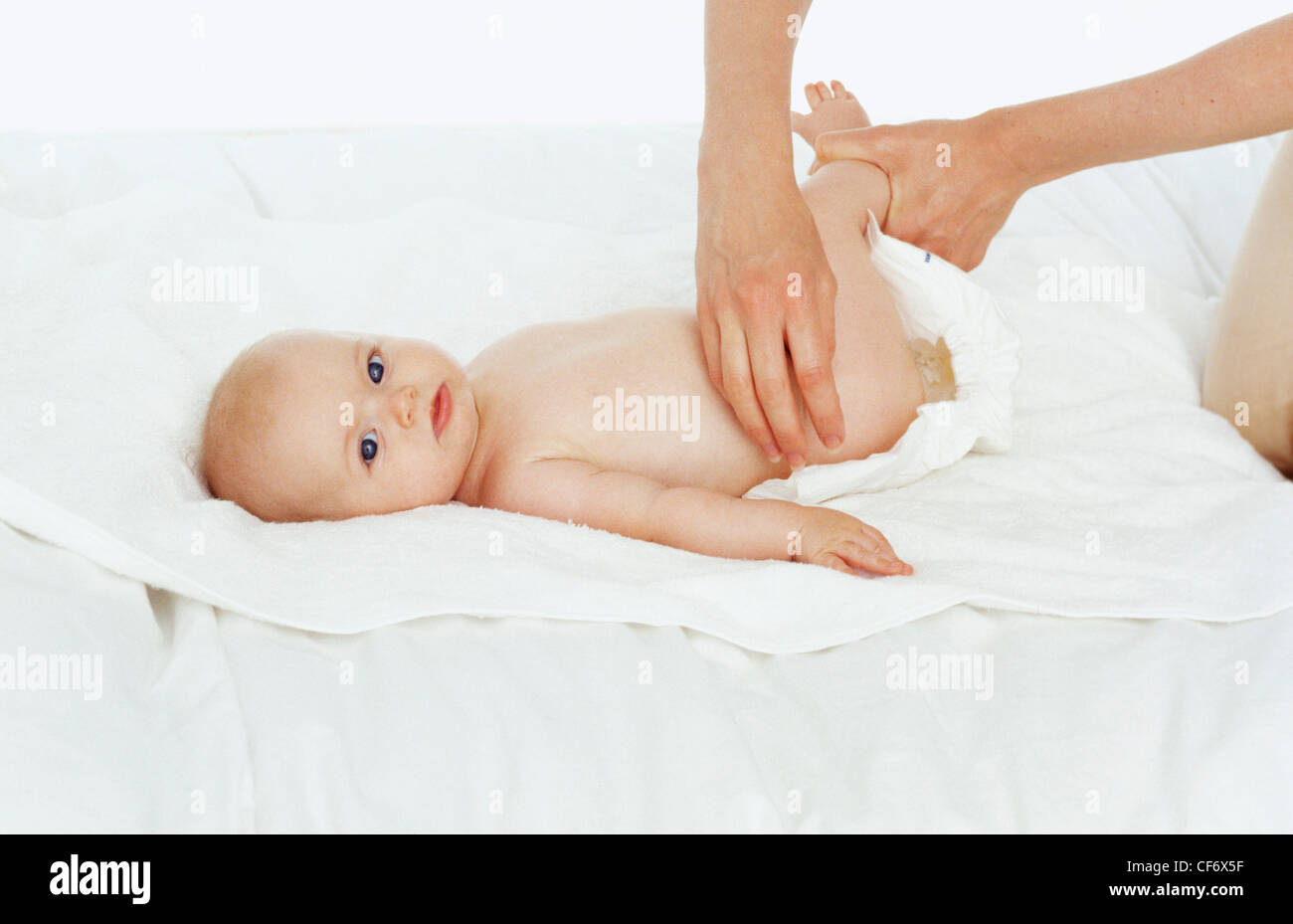 Step by step changing nappy Anonymous female holding up babys legs in