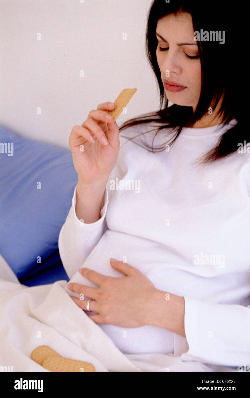 Semi profile of heavily pregnant female long hair wearing