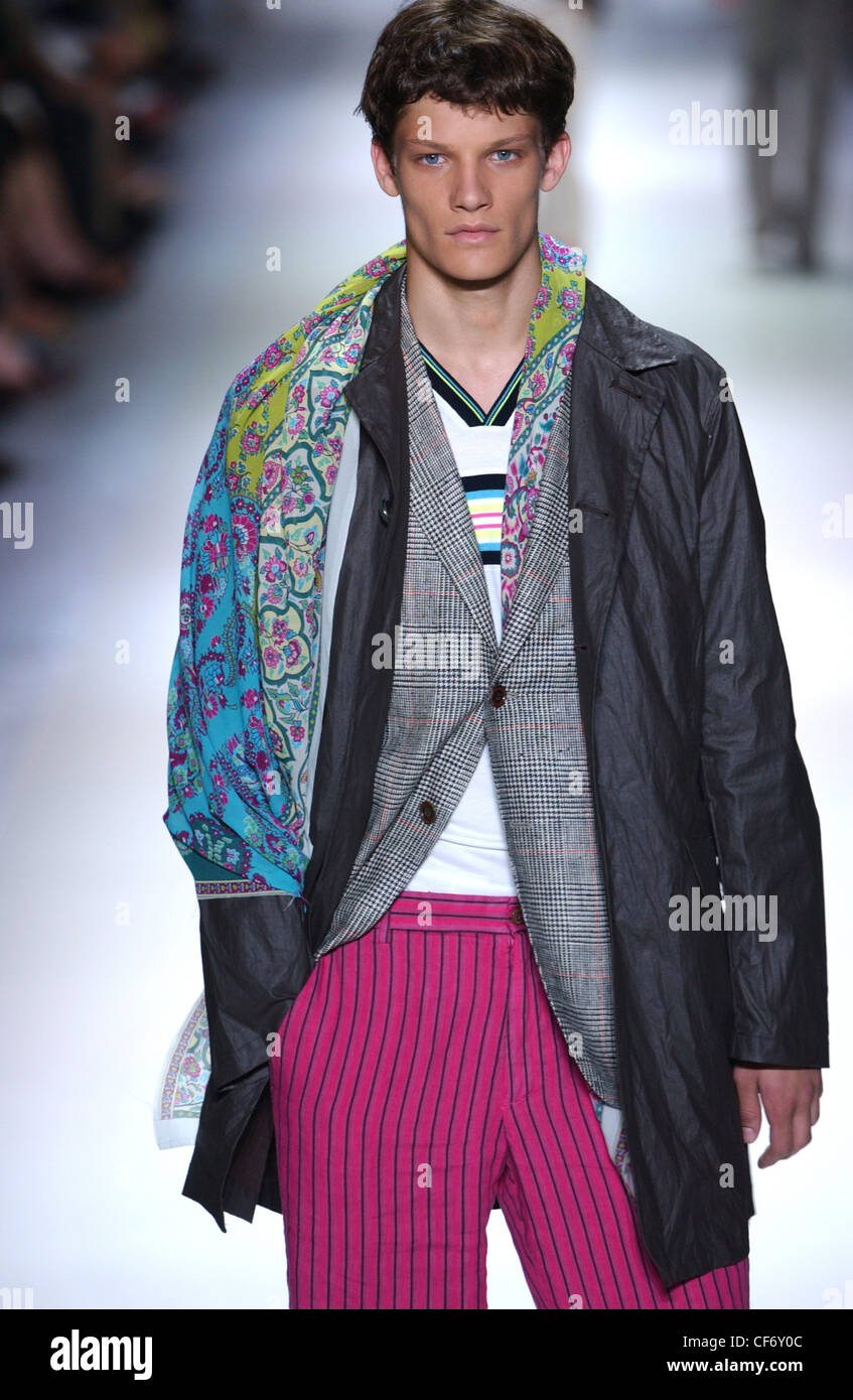 Etro Milan Menswear S S Black mac worn over grey checked jacket striped pink trousers, accessorized paisley print scarf Looking Stock Photo