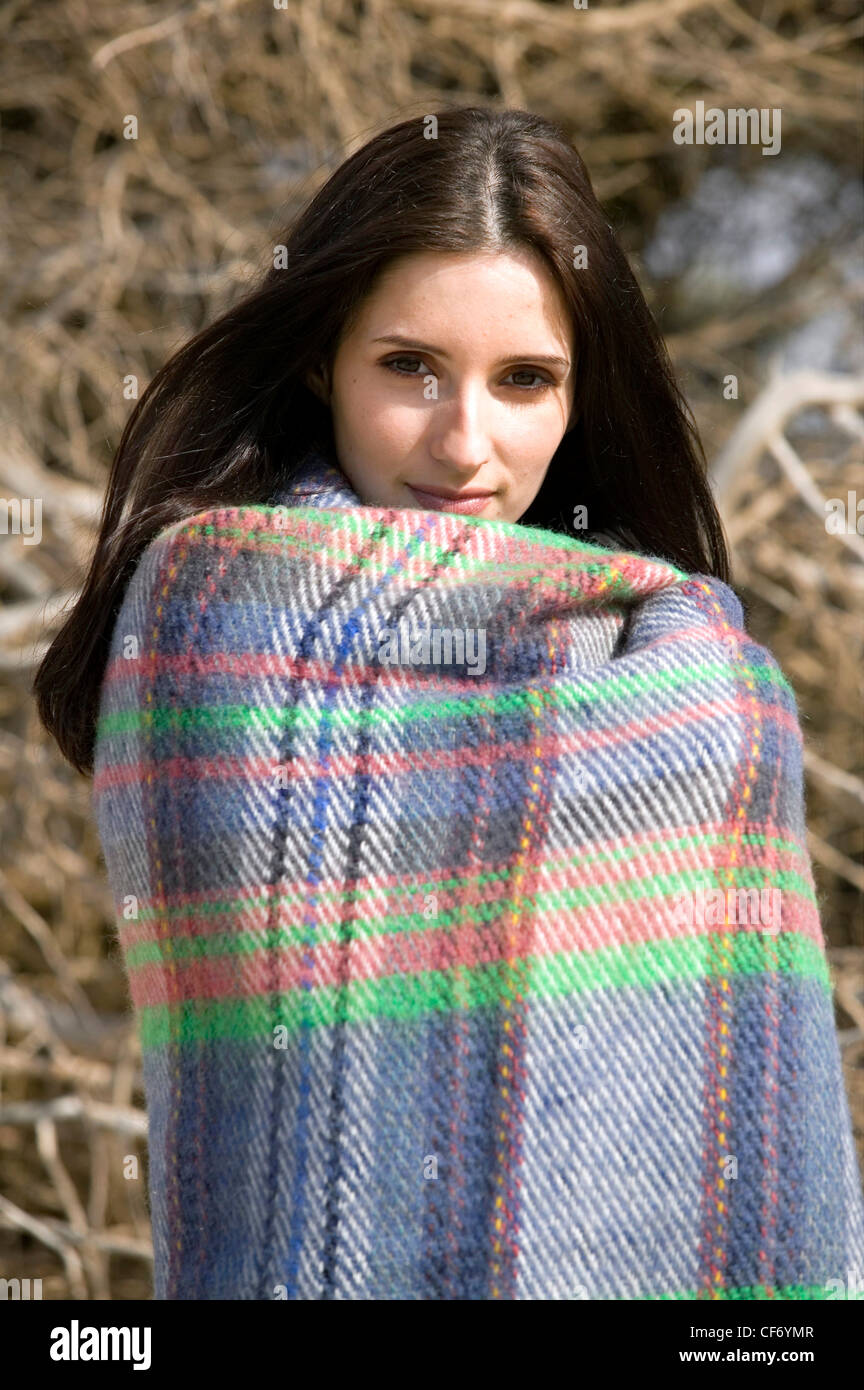 Female with long straight hair holding a woollen tartan