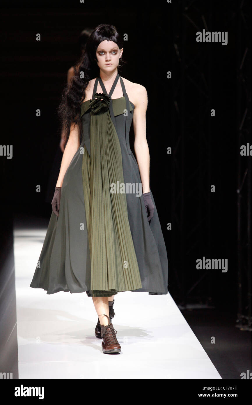 Female model long black hair wearing a calf length green apron dress a ...