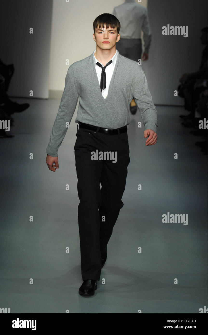 Calvin Klein Milan Menswear Ready to Wear Autumn Winter Monochrome: Male model fringed hair wearing grey V neck pullover over Stock Photo - Alamy Calvin Klein Milan Menswear Ready to Wear Autumn Winter Monochrome: Male model fringed hair wearing grey V neck pullover over Stock Photo - Alamy