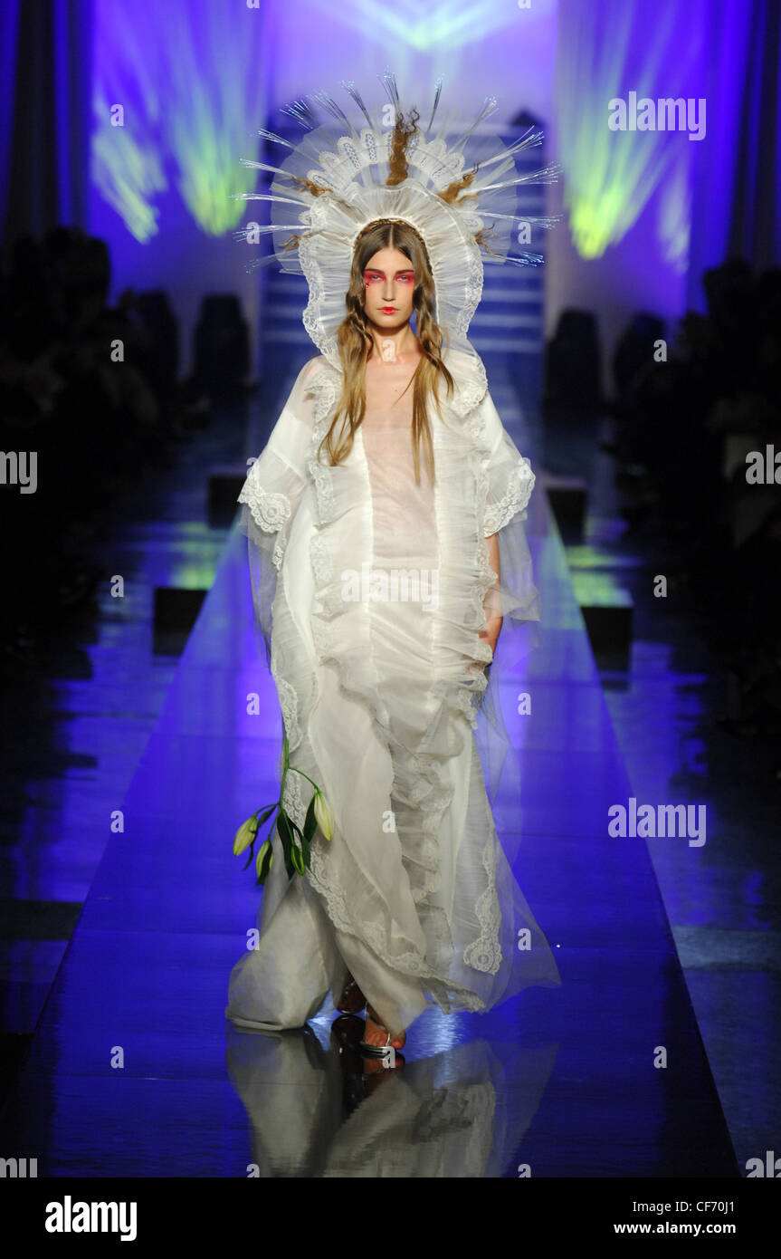 Jean Paul Gaultier Paris Haute Couture Spring Summer Religious Inspired: Model straight hair and red eye makeup holding a bunch Stock Photo