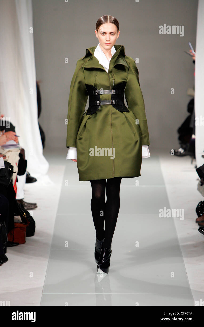 Brioni Milan Fashion Week Autumn Winter Model wearing olive green satin coat tulip shape skirt black belted corset at waist Stock Photo Alamy
