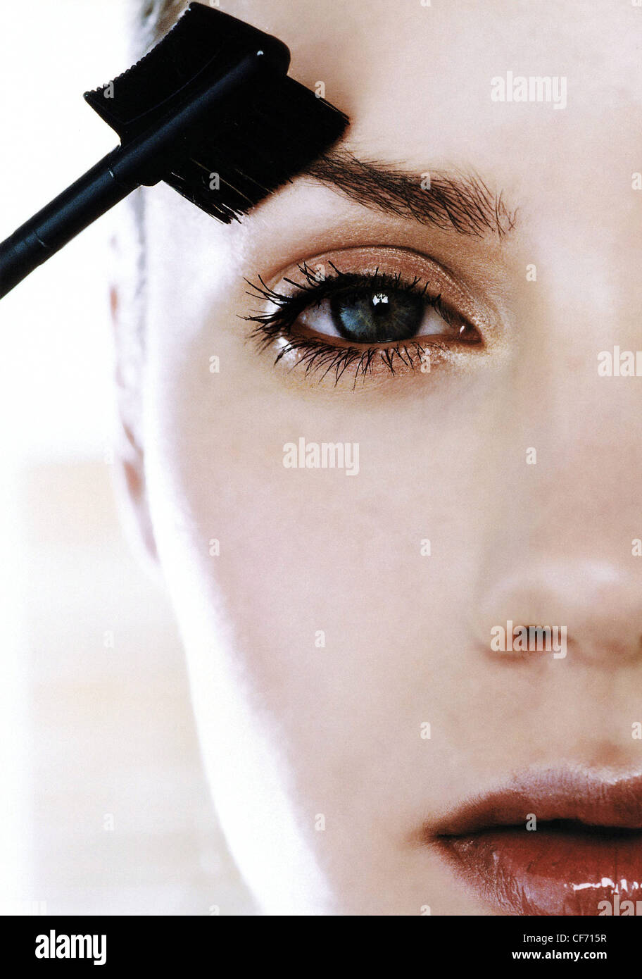 Female brushing eyebrows with eyebrow brush Andrea Ciriminna Stock