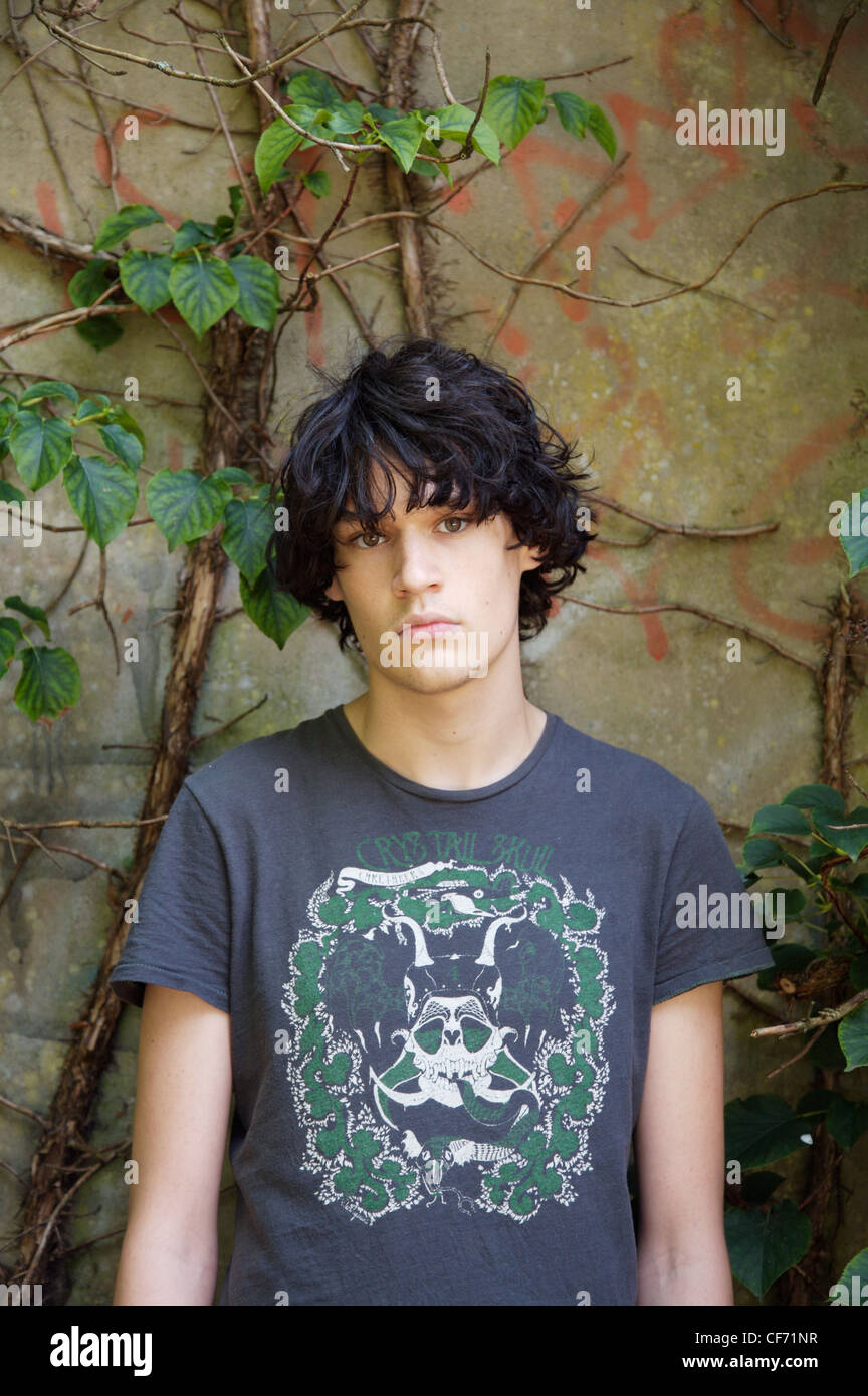 Teenage Male With Black Wavy Hair Wearing A Grey Motif T Shirt