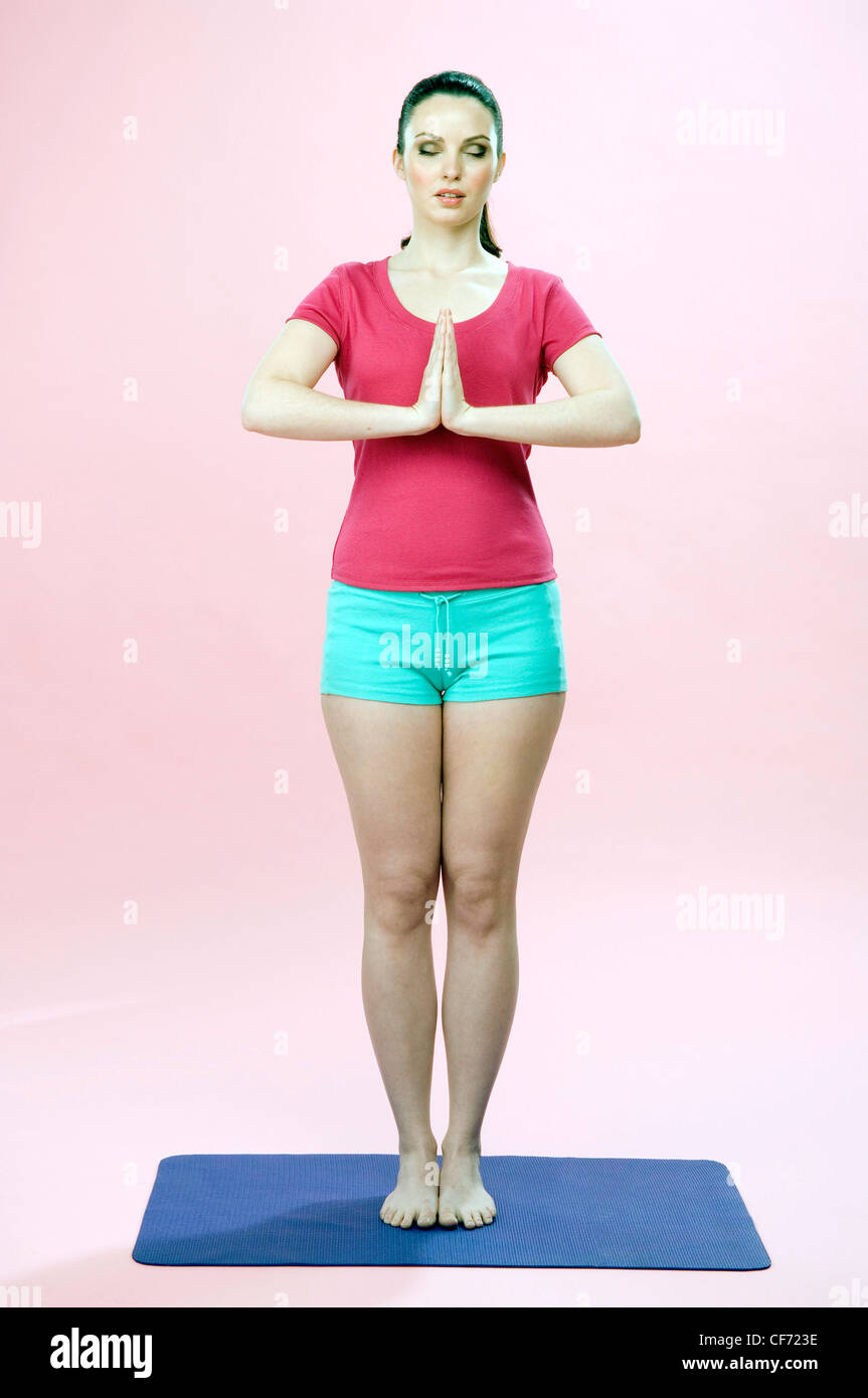 Female standing feet together hands hires stock photography and images