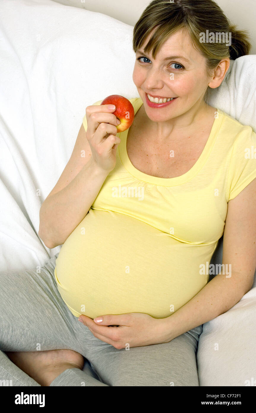 Pregnant Female eating an apple Stock Photo Alamy