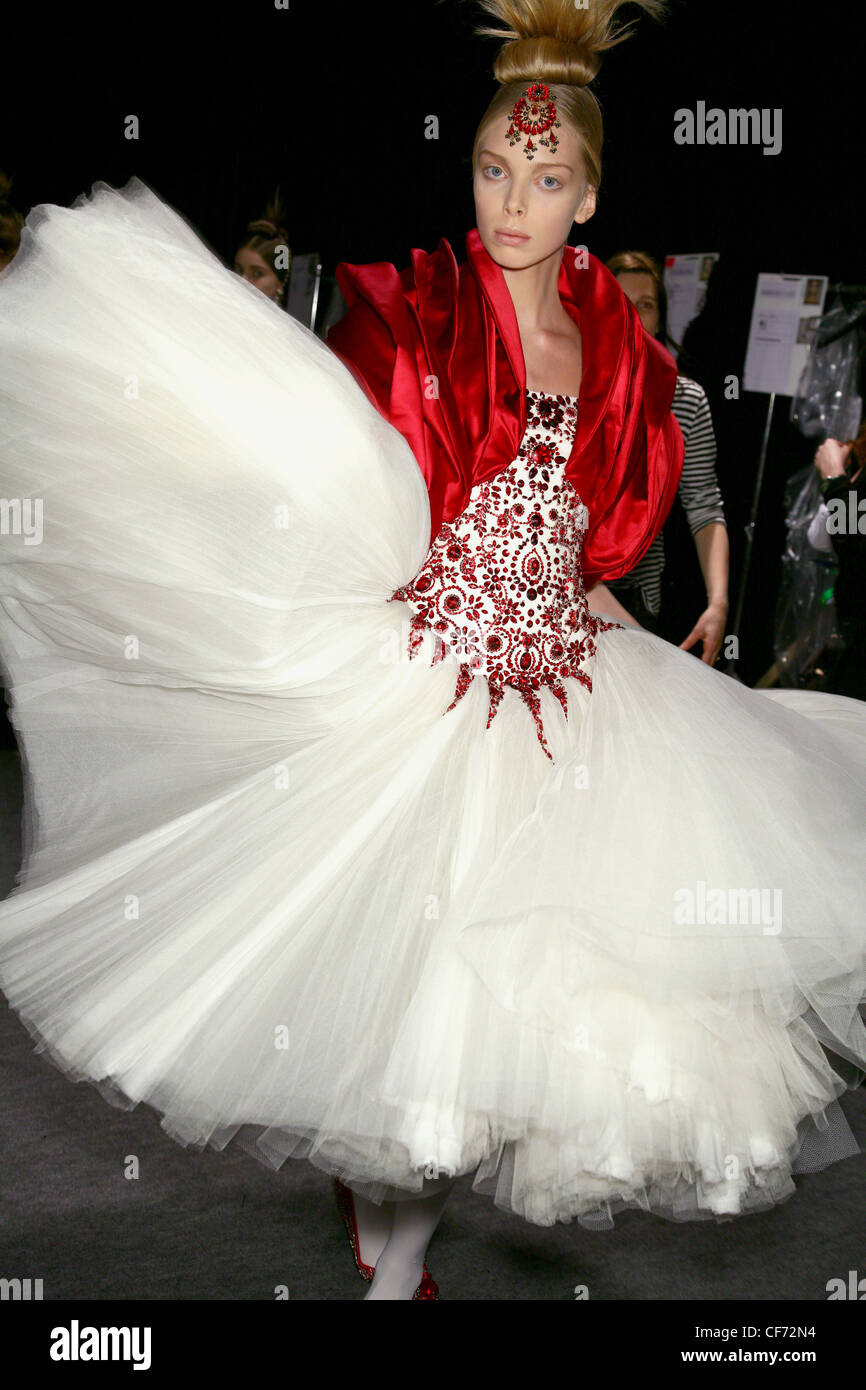 Backstage Alexander McQueen Paris Ready to Wear Autumn Winter 2008 2009  Model wearing a white dress a full tulle skirt, a red Stock Photo - Alamy