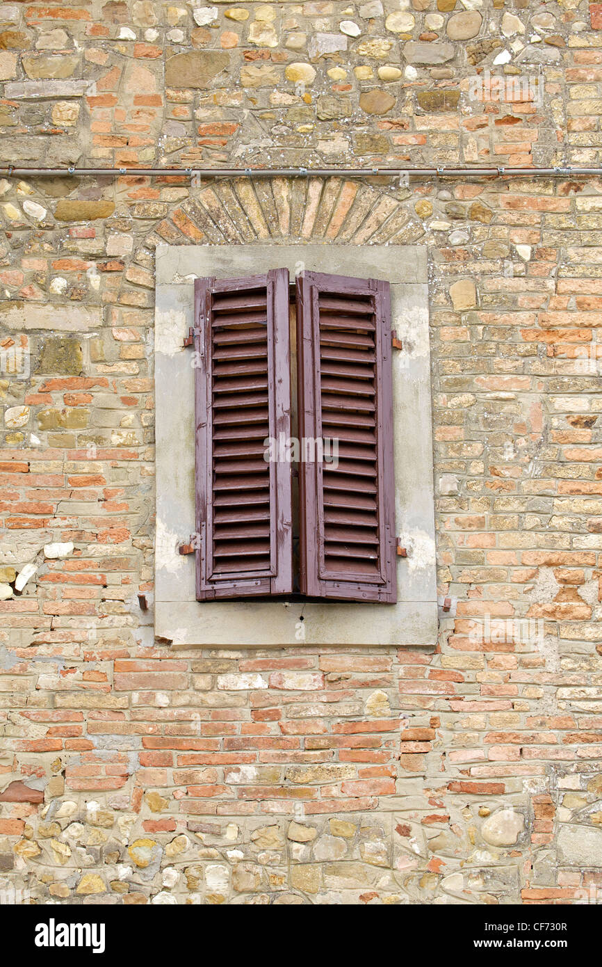 Brown Wood Shutters on a Weathered Brick Wall in Tuscany Stock Photo