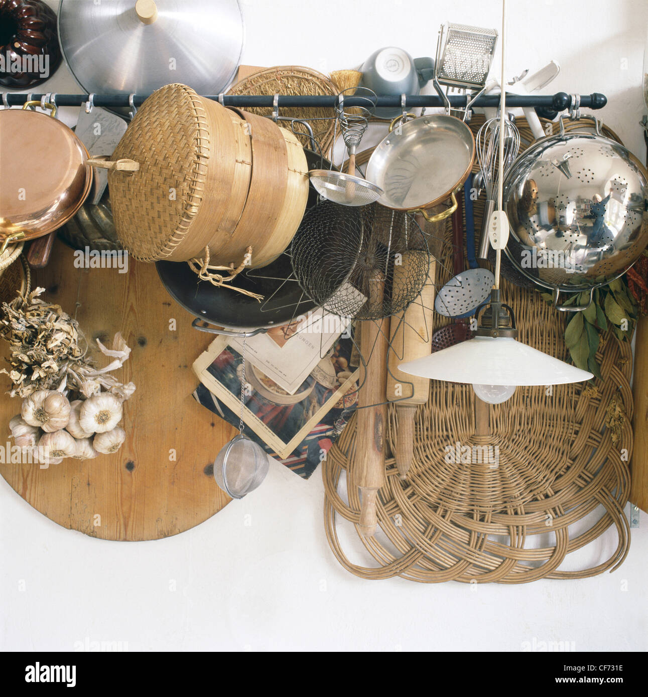 Selection of mismatched kitchen equipment hanging on a rail, including ...