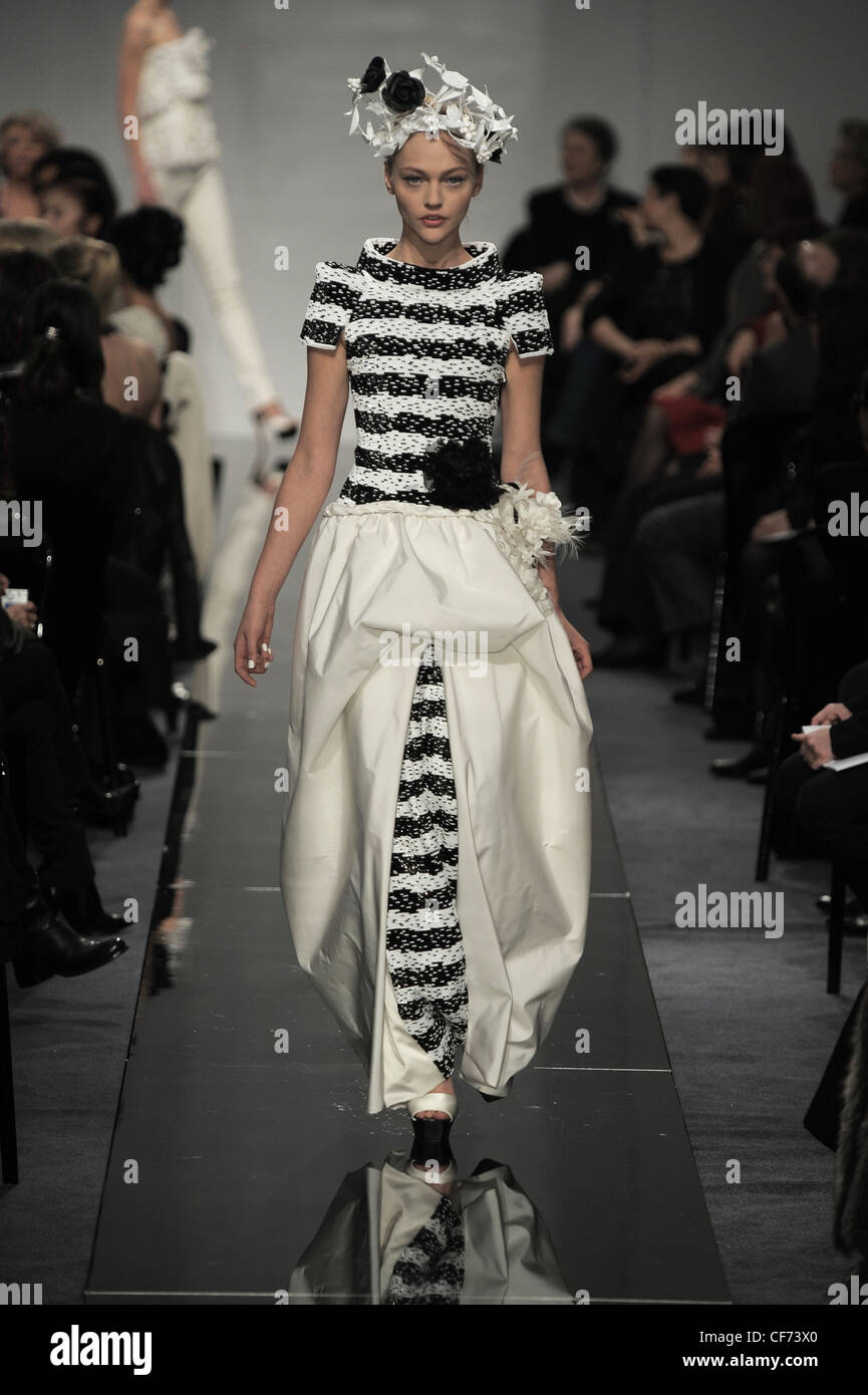 Chanel Paris Haute Couture Spring Summer Monochrome: wearing black and white striped dress gathered drape, accessorized floral Stock Photo