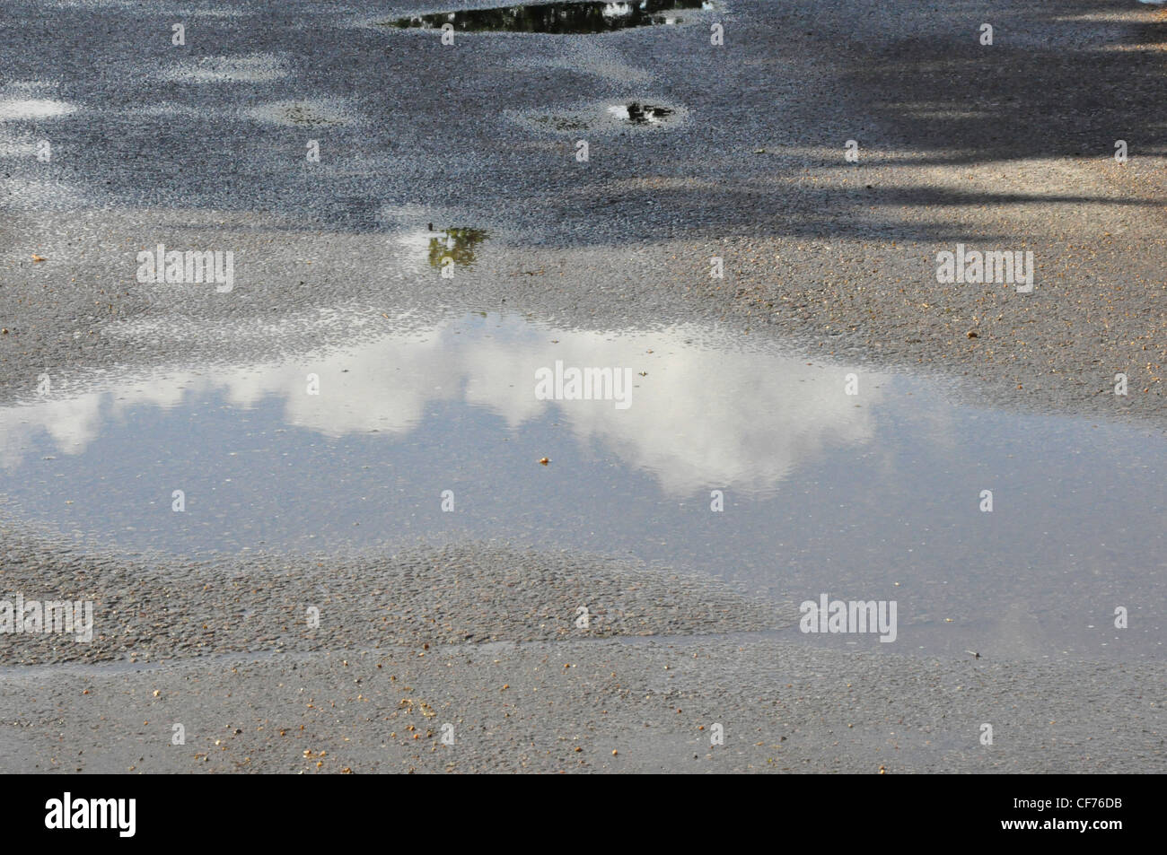 Summer sky reflected in rain puddles Stock Photo