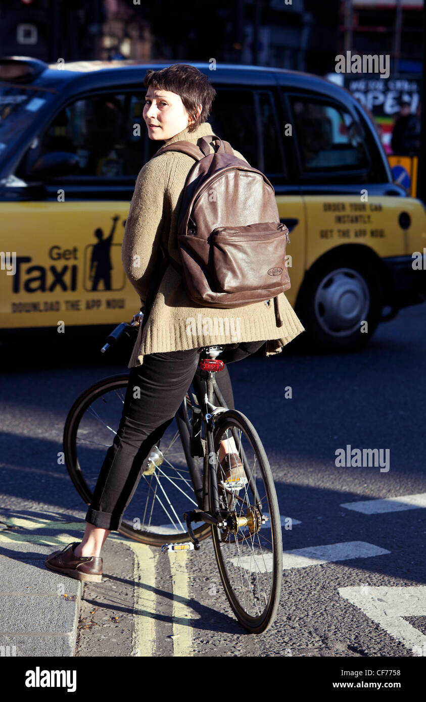 Full Length portrait of a female bicycle rider on the street, London, England, UK. Stock Photo