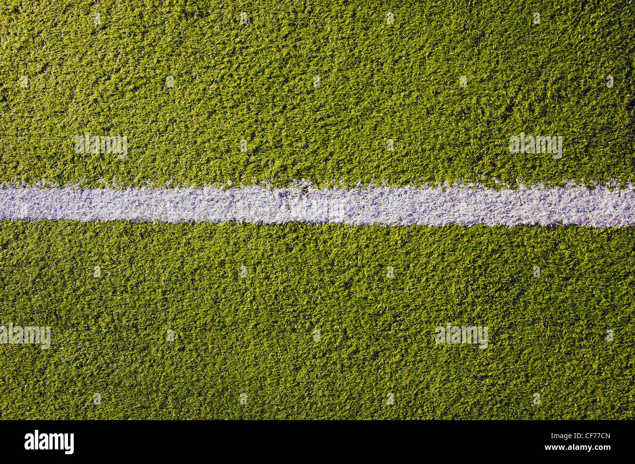 Synthetic sports pitches athletic green surface and white markings closeup background backdrop. Stock Photo
