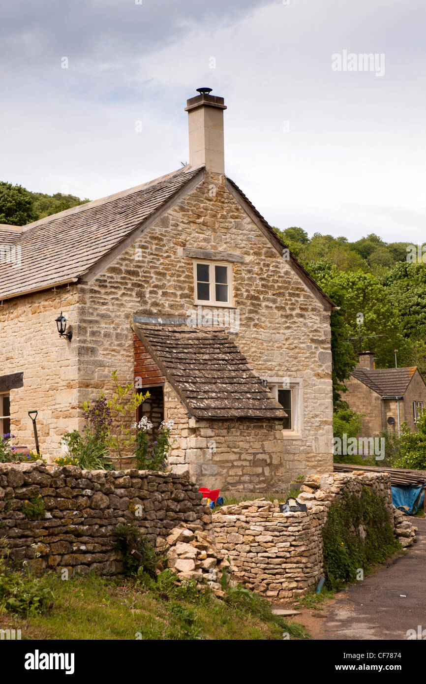 UK, Gloucestershire, Stroud, Slad Valley, village house being renovated, rebuilding stone wall Stock Photo