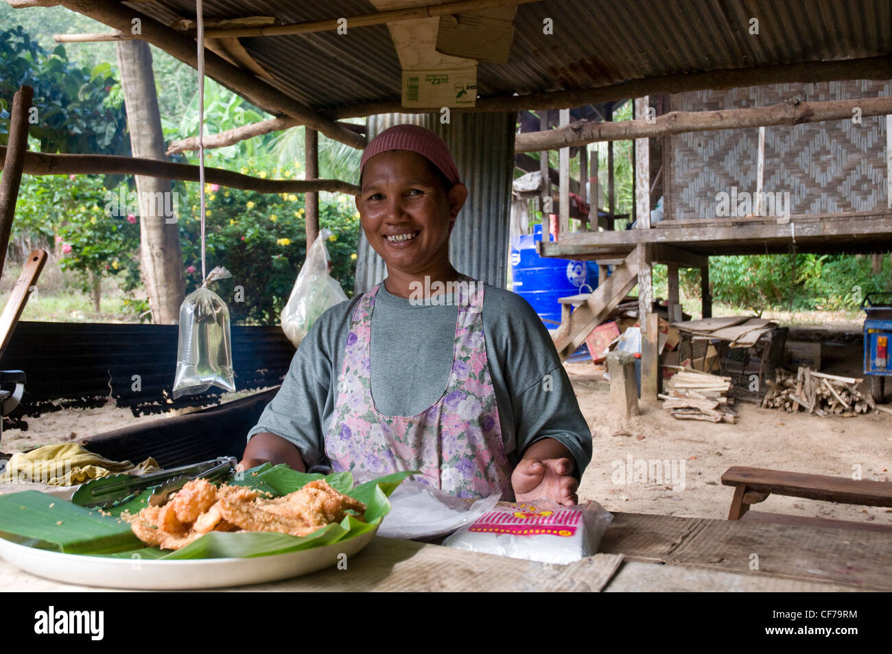 Woman serving traditional Thai food from a beach cafe, Koh Bulon, Thailand Stock Photo