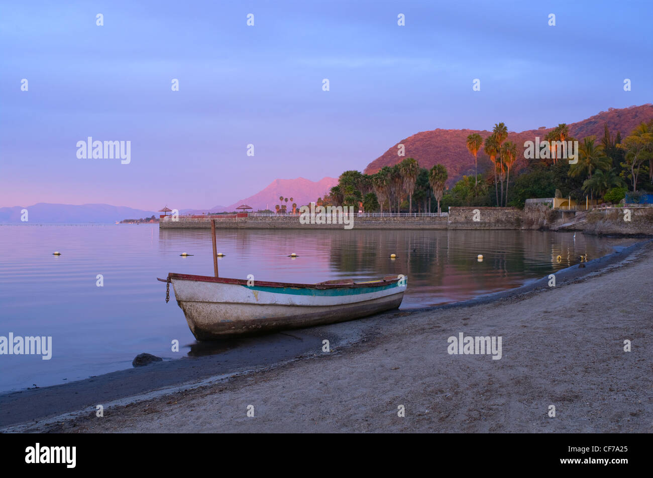 Lake Chapala in Jalisco Mexico glows in morning dawn with fishing boat