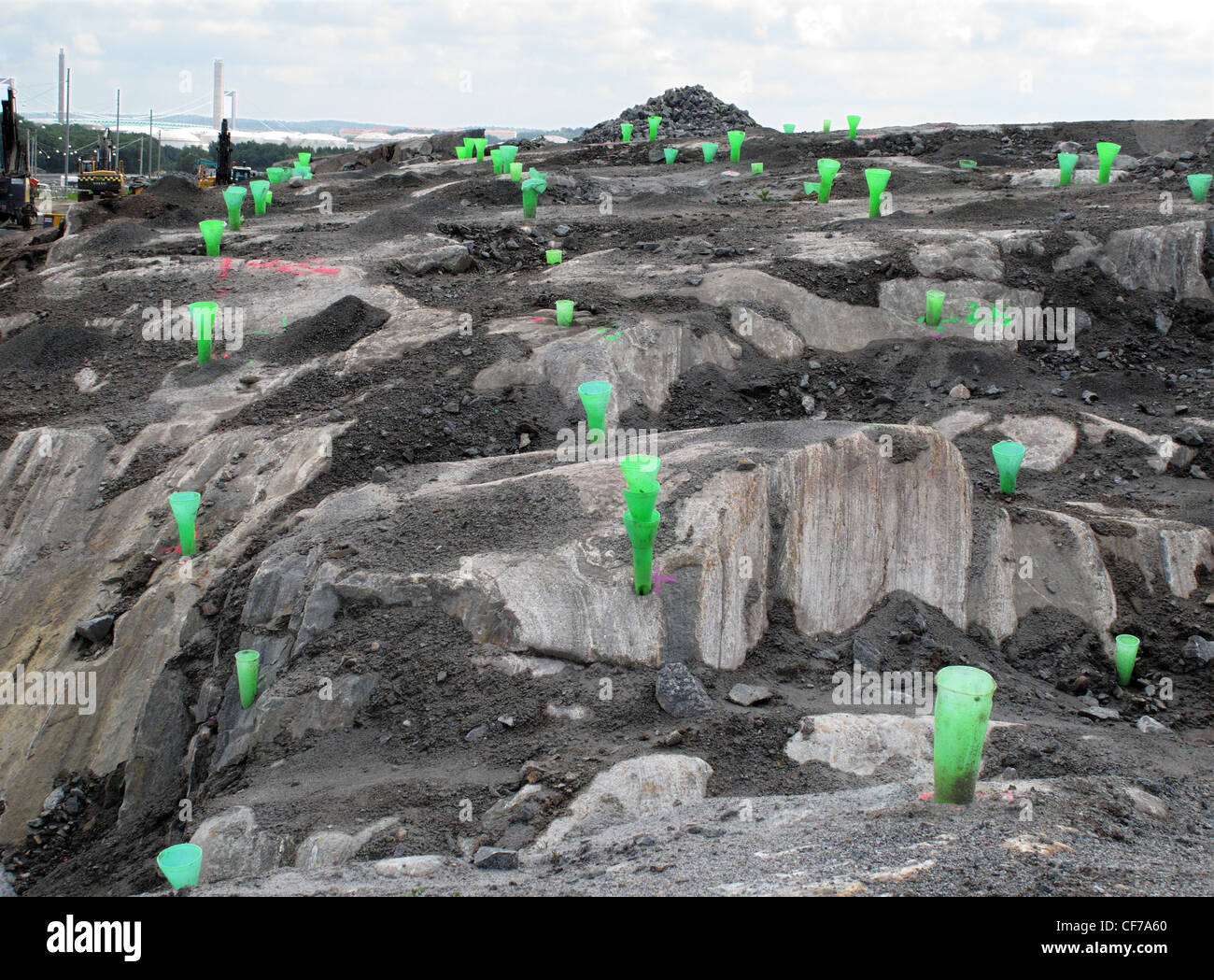 Rocky field with holes drilled and prepared for dynamiting rock