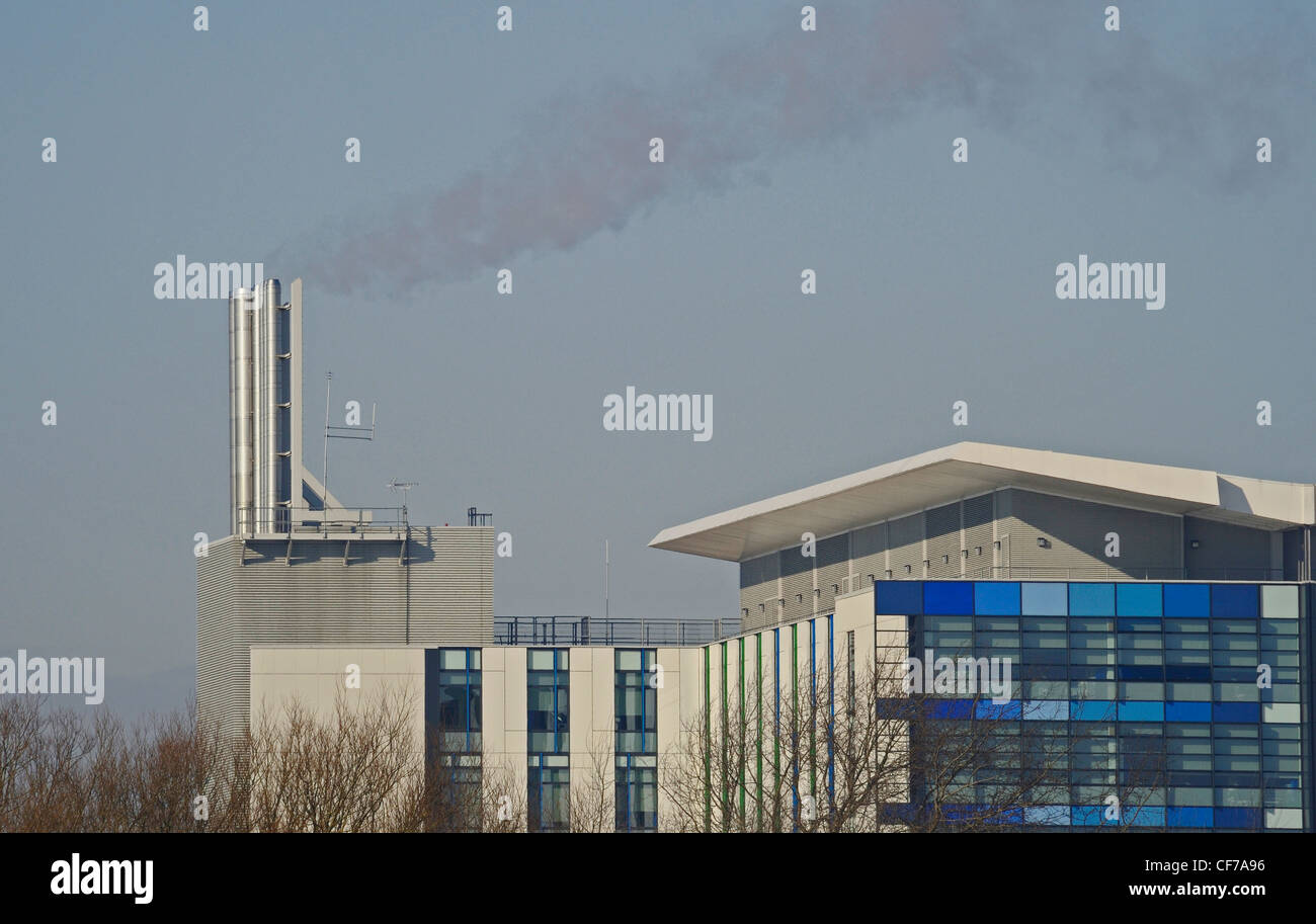 Steam and hot exhaust gases being emitted through steel chimneys at a