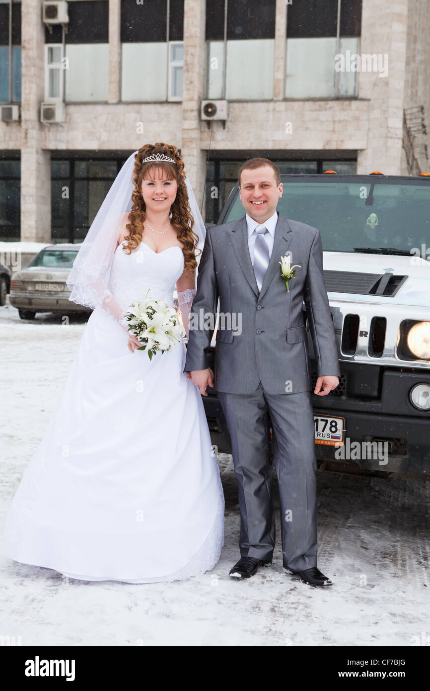 Bride and groom standing near car limousine in winter season Stock ...