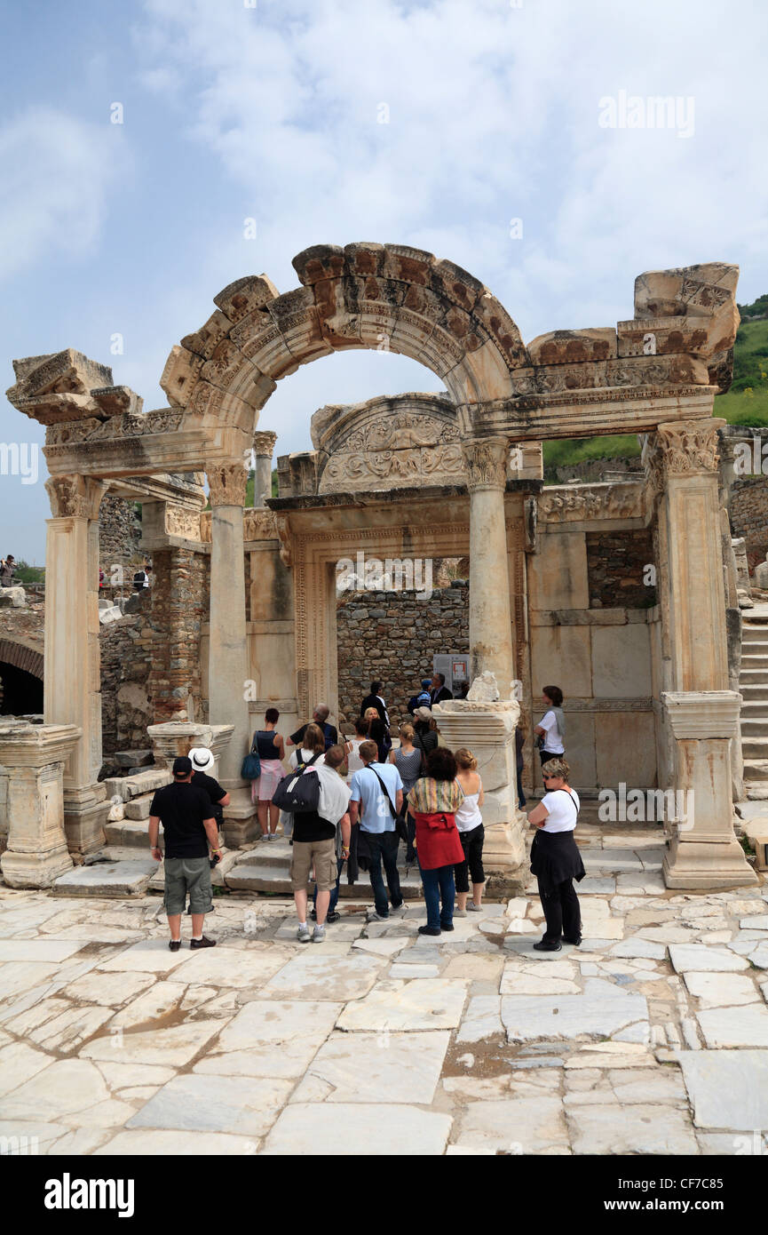 Tourists people looking at the ruins of Hadrians arch entrance to The Temple of Hadrian Ephesus Turkey Stock Photo