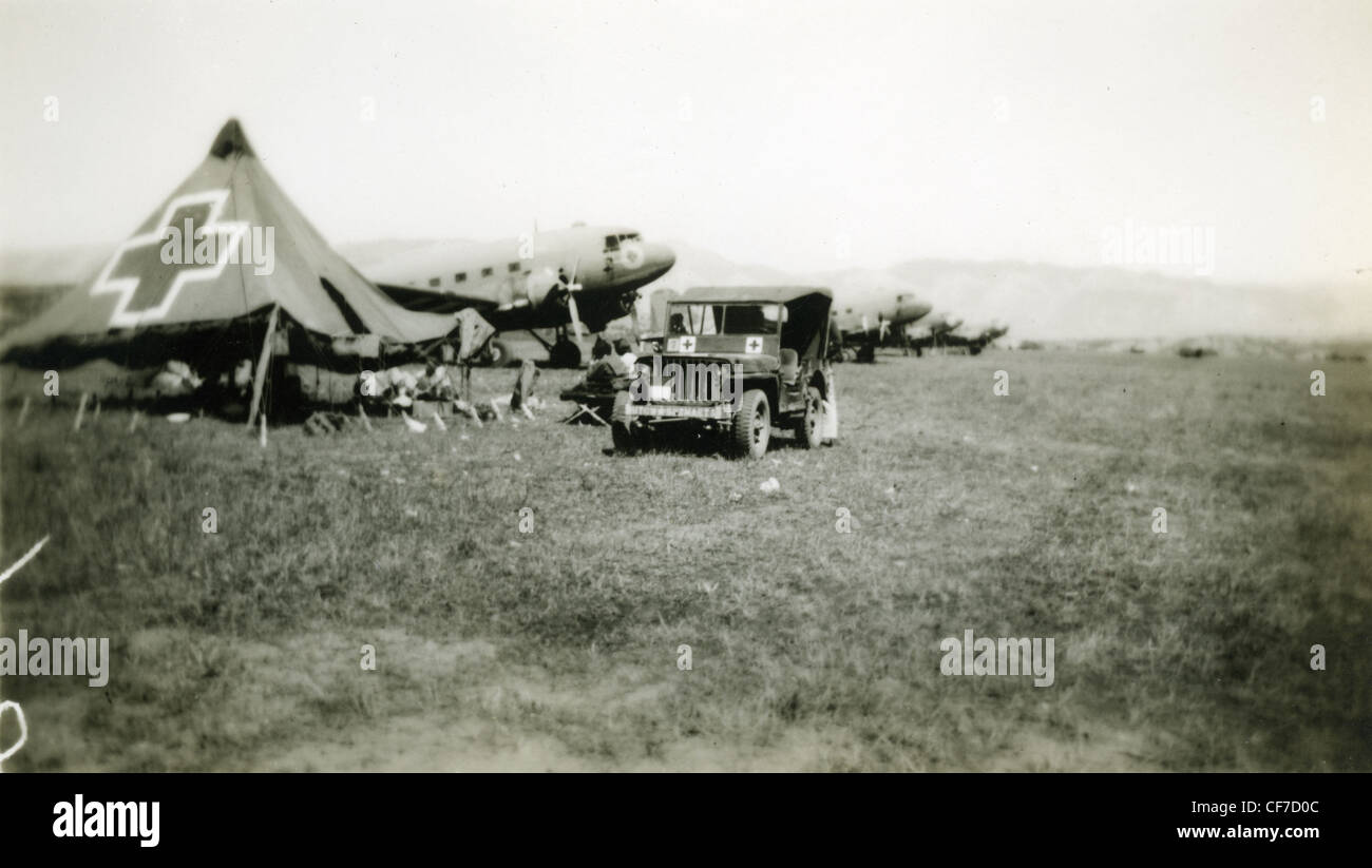 Jeep parked next to medical medic's tent and C47 airplane during WWII world war II field hospital medical care willys jeep 4WD f Stock Photo