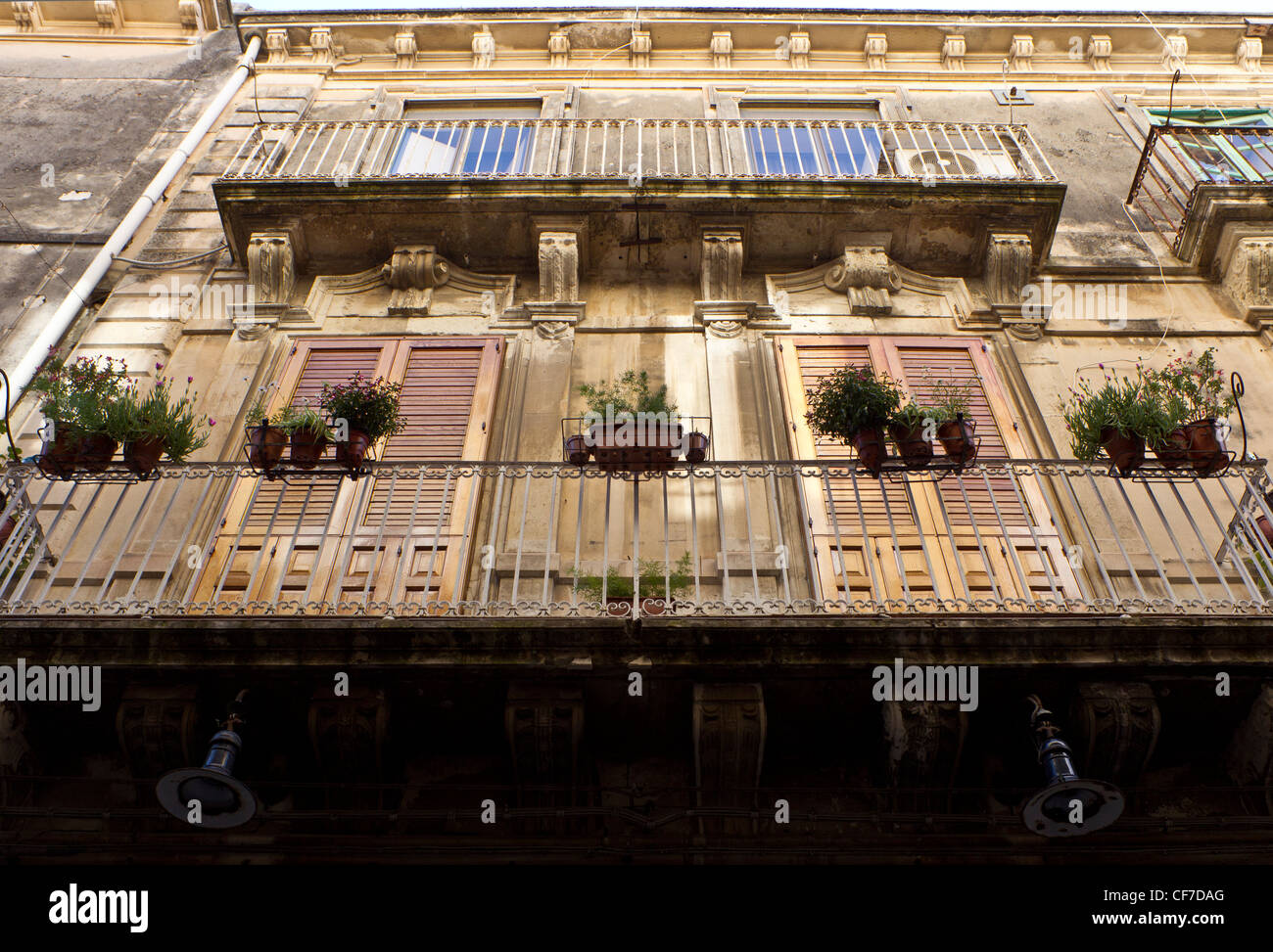 Looking upwards at the side of a building illustrating Sicilian Baroque architectural style with characteristic balconies Stock Photo