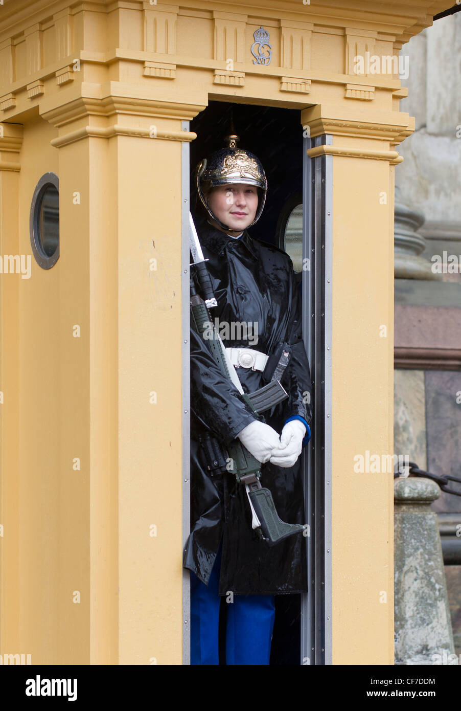 Swedish Royal Palace guard (female) in her sentry box, in uniform and armed with a machine gun Stock Photo