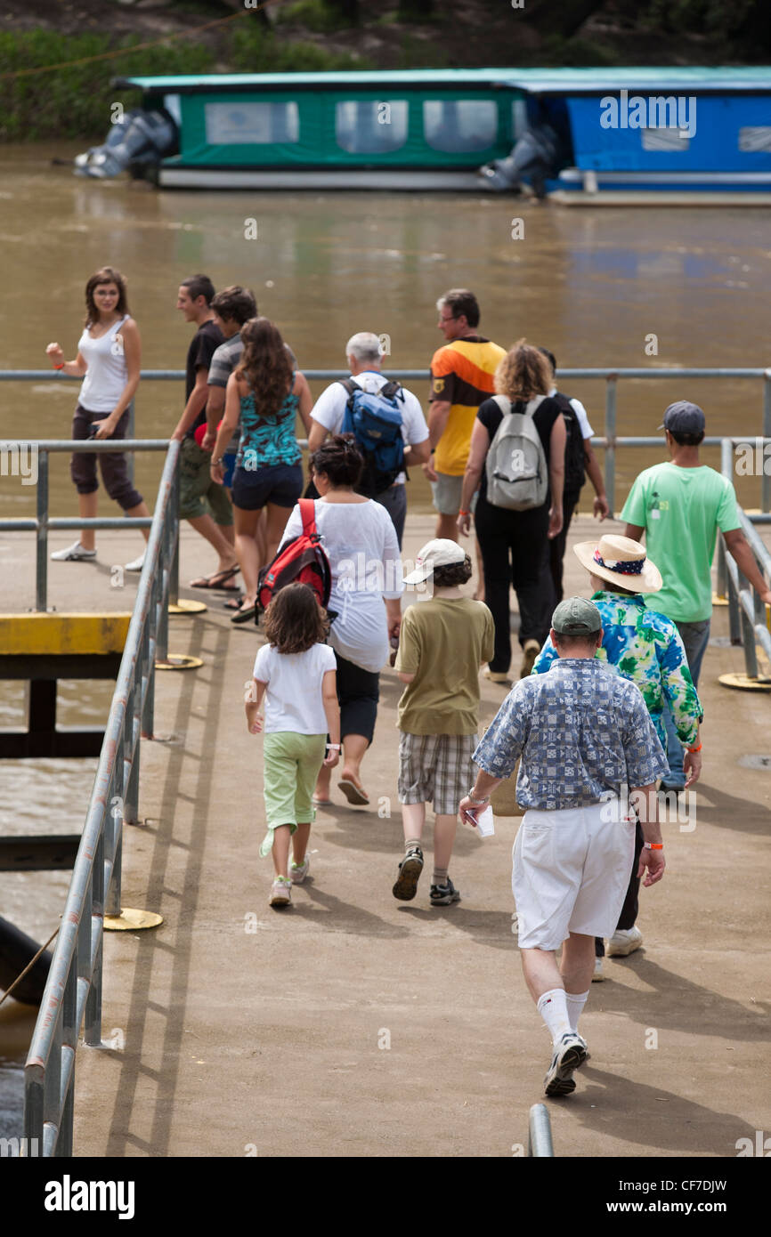Passengers walk down the dock to boat taking tourists on a tour of the Rio Sarapiqui in Puerto Viejo de Sarapiqui in Costa Rica Stock Photo