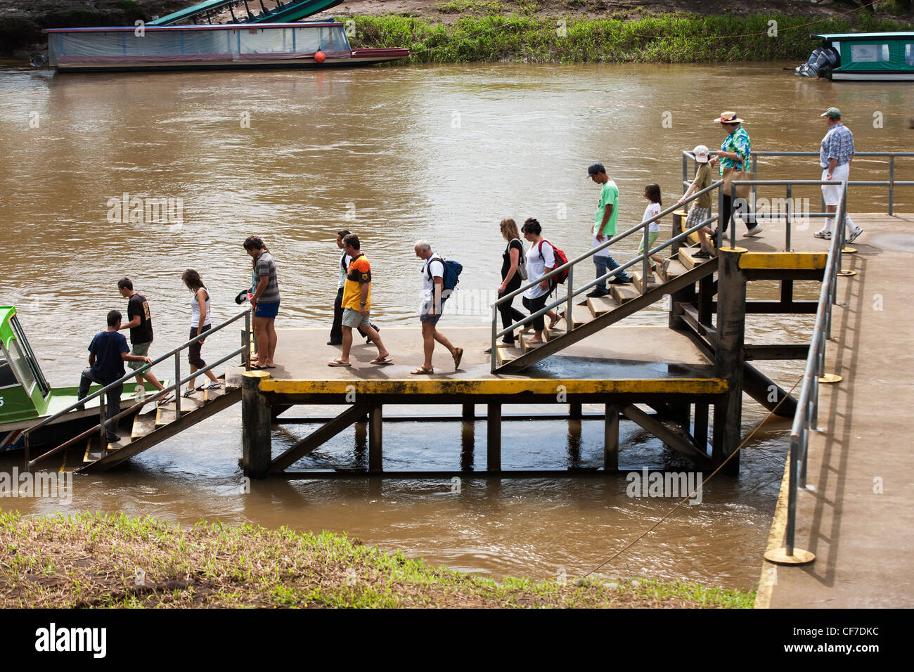 Passengers walk down the dock to boat taking tourists on a tour of the Rio Sarapiqui in Puerto Viejo de Sarapiqui in Costa Rica Stock Photo