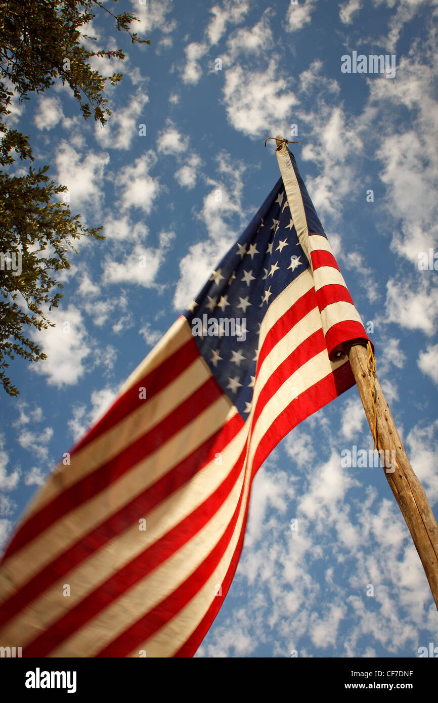 US Flag waiving in the wind and shot against a deep blue sky with white clouds. Stock Photo